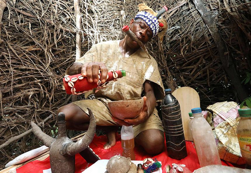традиционный целитель в своем святилище в деревне Магбумох, смешивает травы в зелья 1 декабря 2018 года. -