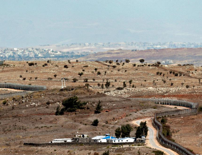 На снимке, сделанном 6 октября 2017 года, изображен израильский оборонительный забор, извивающийся, отделяющий оккупированный Израилем сектор Голанских высот (слева) от Сирии около Кунейтры, 2017 год