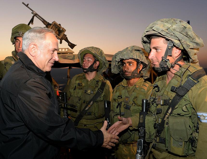 Премьер-министр Израиля Биньямин Нетаньяху (слева, на переднем плане) пожимает руку солдату Армии обороны Израиля (ЦАХАЛ) во время своего визита на Голанские высоты 15 октября 2013 года